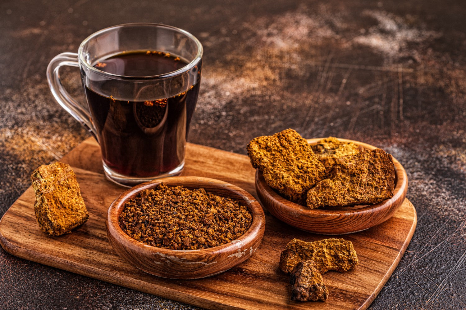 A cup of chaga mushroom tea surrounded by chaga mushroom pieces